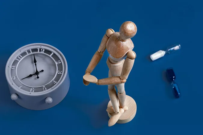 Un mannequin en bois se tient à côté d'une horloge.